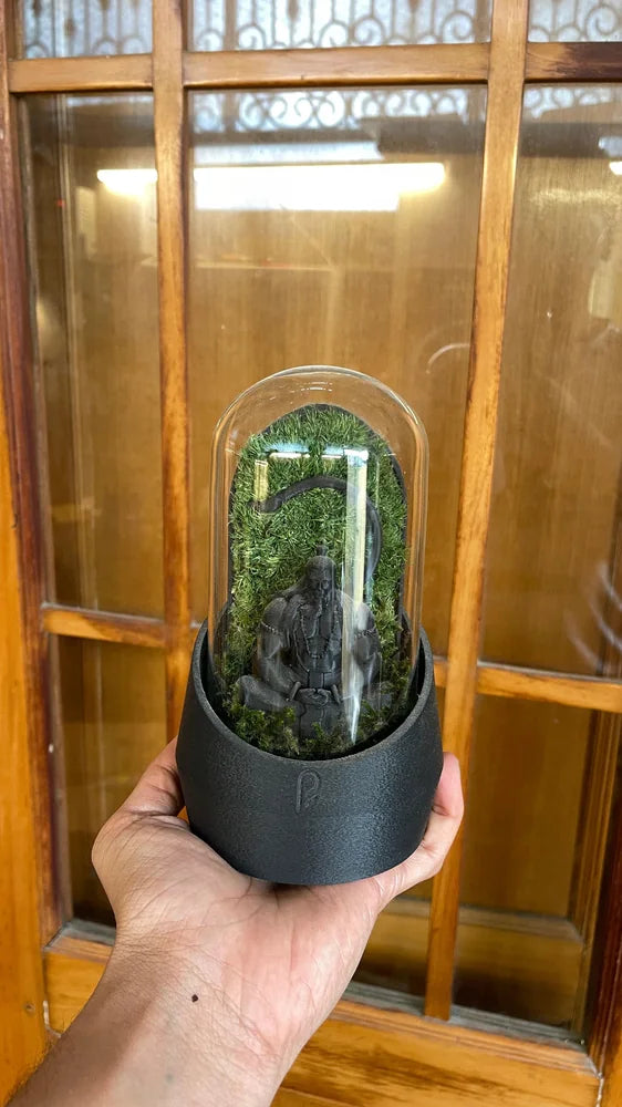 Black-based figurine dome held near a window