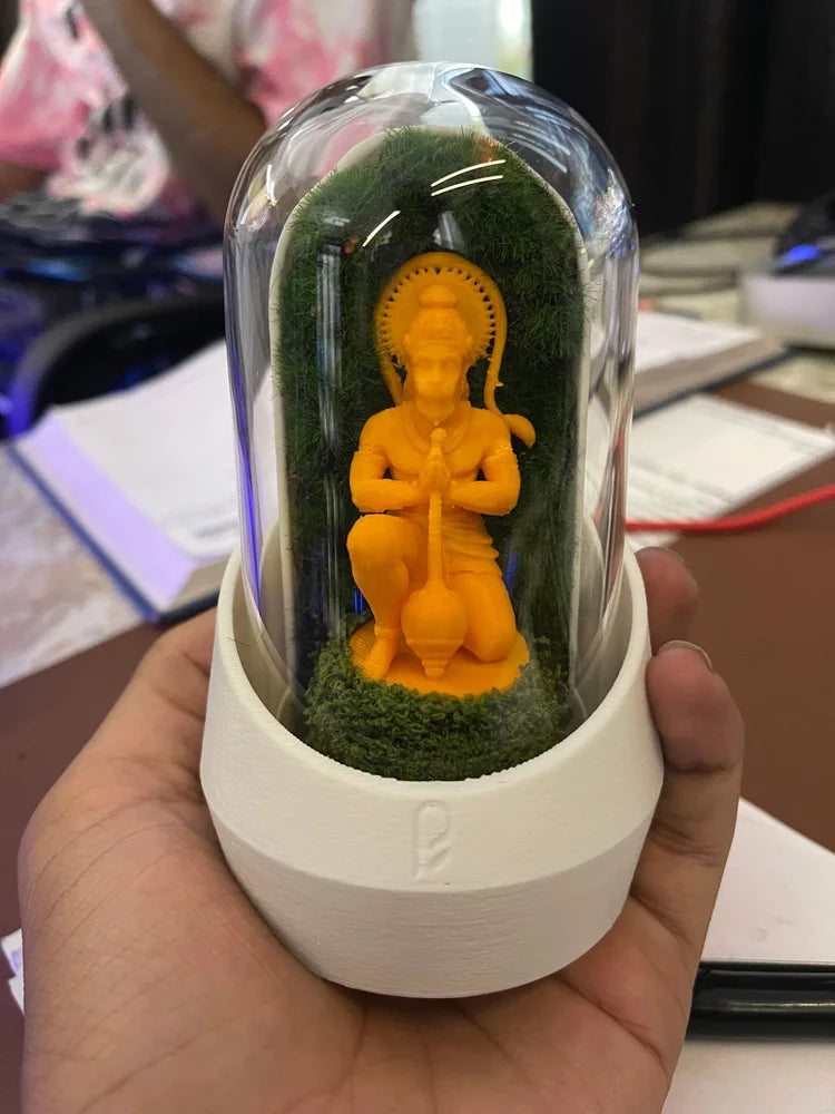 Yellow figurine inside a white-based moss dome